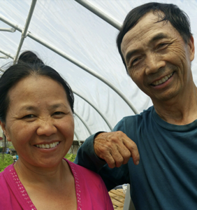 Farmers Choua and Kia of Greenleaf Farm inside a greenhouse.